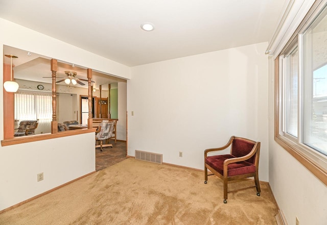 living area with carpet, visible vents, a ceiling fan, and baseboards