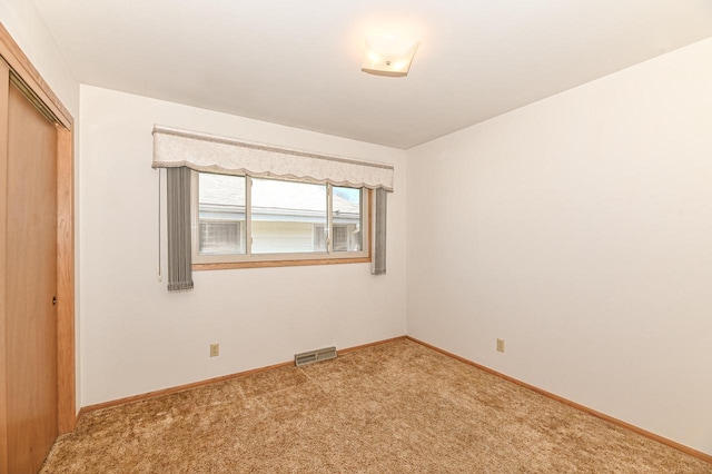 unfurnished bedroom with a closet, visible vents, carpet, and baseboards