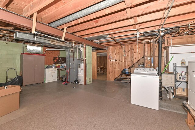 unfinished below grade area featuring gas water heater and washer / dryer