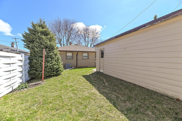 view of yard featuring fence and central air condition unit
