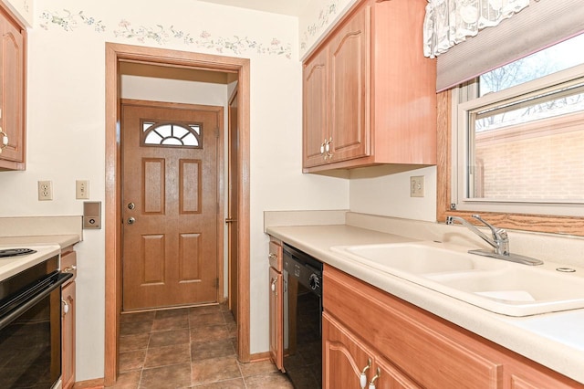 kitchen featuring black dishwasher, light countertops, a sink, and range with electric cooktop