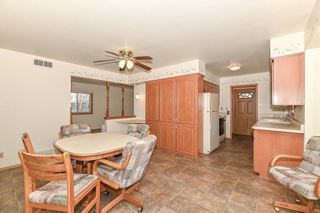 dining room featuring stone finish floor, visible vents, and a ceiling fan