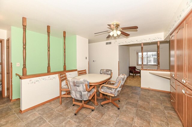dining room featuring stone finish floor, visible vents, and a ceiling fan