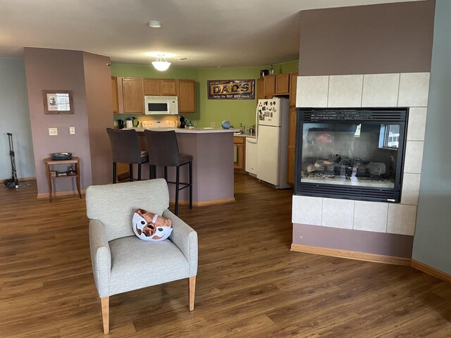 kitchen with baseboards, white appliances, and dark wood-type flooring