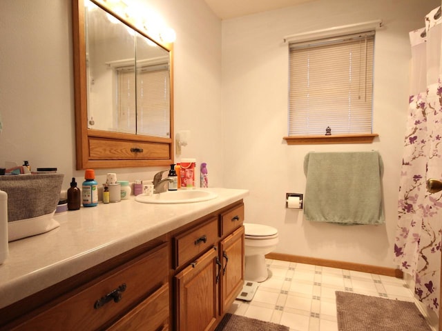 bathroom with tile patterned floors, baseboards, toilet, and vanity