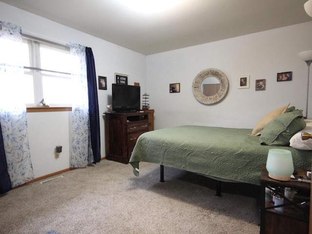 bedroom featuring light carpet and baseboards