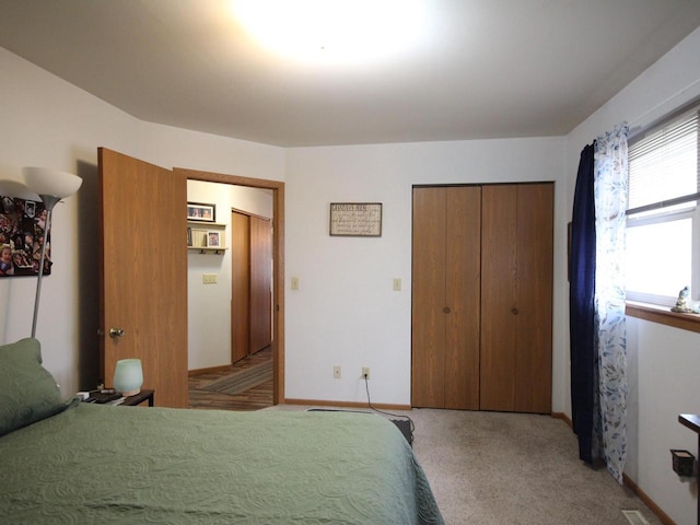 bedroom with light colored carpet, baseboards, and a closet