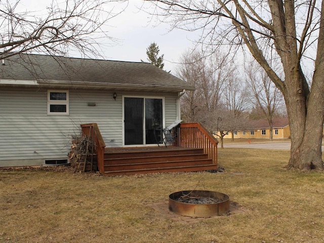 rear view of property featuring a lawn and a shingled roof
