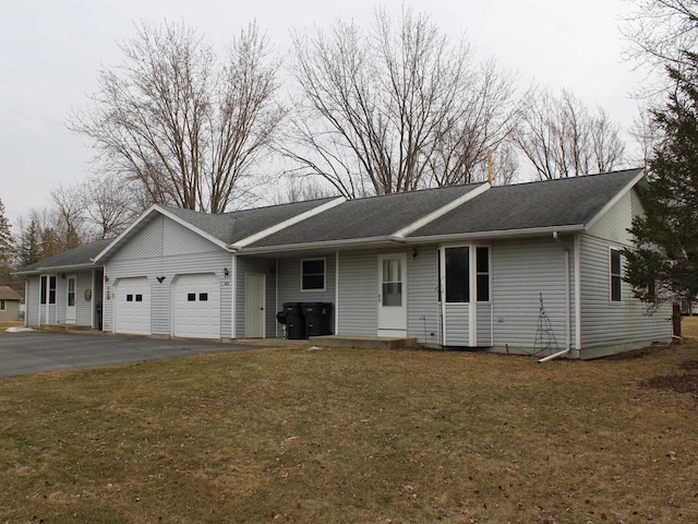 ranch-style house with driveway, roof with shingles, a front yard, and a garage