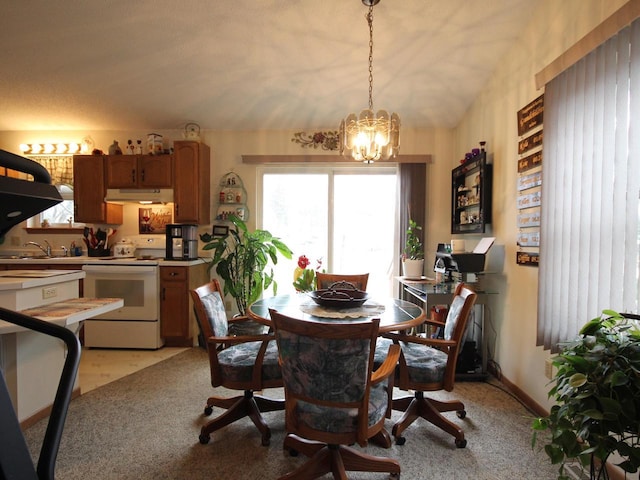 dining room featuring a chandelier, light carpet, and vaulted ceiling