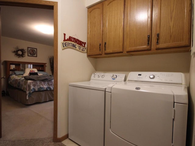 laundry area featuring washing machine and clothes dryer, cabinet space, and carpet floors