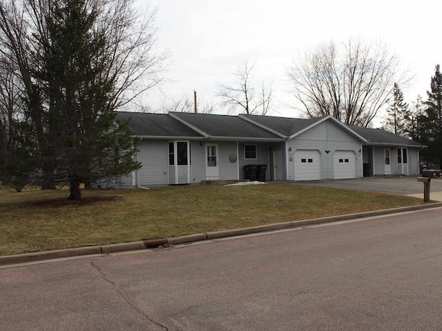 ranch-style home with a garage, a front lawn, and driveway