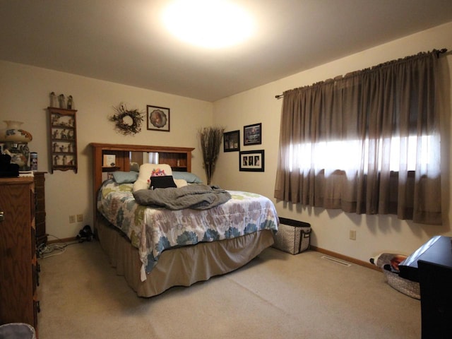 bedroom with visible vents, light colored carpet, and baseboards