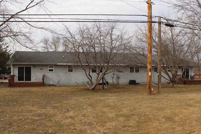 back of property featuring a lawn and a shingled roof
