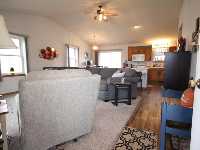 living area with dark wood-style floors, a ceiling fan, lofted ceiling, and baseboards