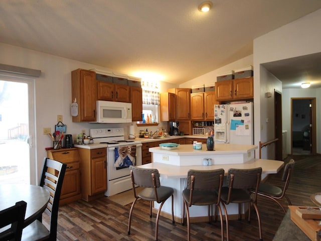 kitchen with a healthy amount of sunlight, white appliances, light countertops, and a center island