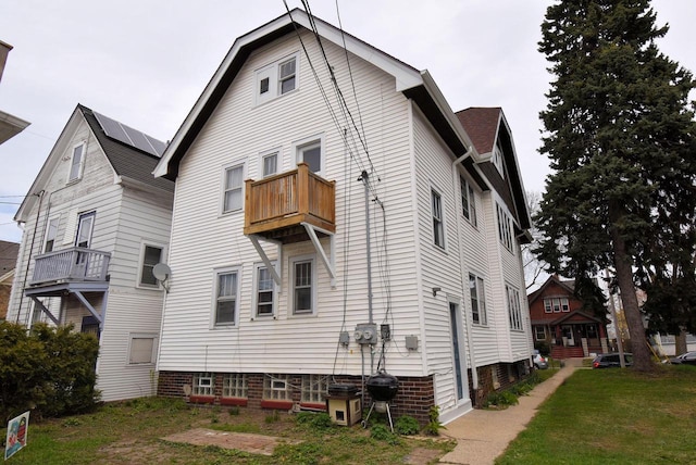 back of property featuring a yard and a balcony