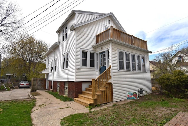 view of front of property with fence and a balcony