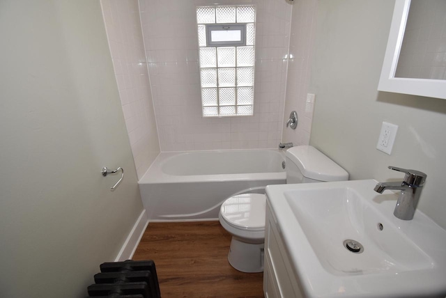 bathroom with toilet, shower / bath combination, a sink, and wood finished floors