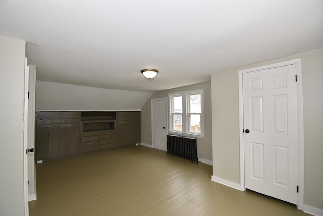 bonus room featuring baseboards, lofted ceiling, radiator heating unit, and wood finished floors