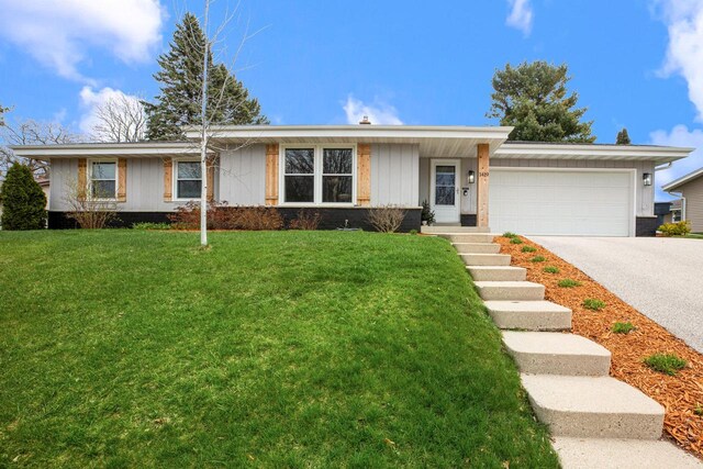 ranch-style home with a front yard, driveway, and an attached garage