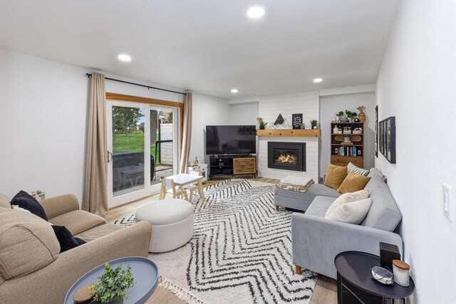 living area featuring recessed lighting, wood finished floors, and a fireplace