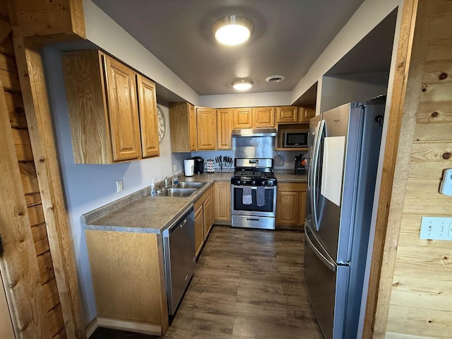 475 Overlook Ct, Warrens, WI 54666 - kitchen featuring brown cabinets, a sink, dark wood-style flooring, under cabinet range hood, and appliances with stainless steel finishes