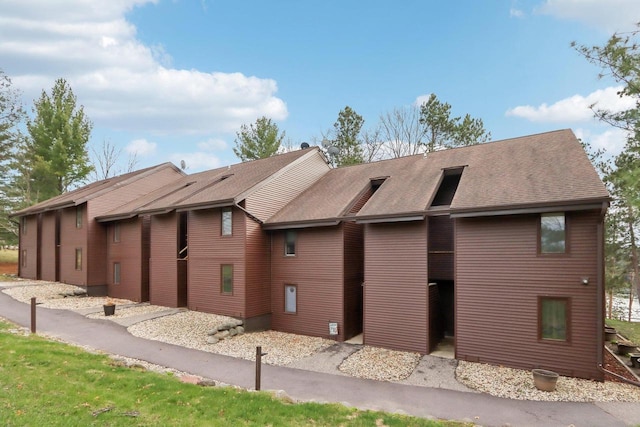 rear view of house with a shingled roof
