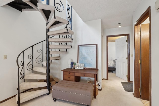 stairs featuring a textured ceiling, carpet flooring, and baseboards
