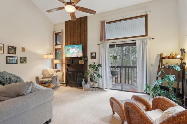 carpeted living room featuring a ceiling fan, high vaulted ceiling, and a fireplace