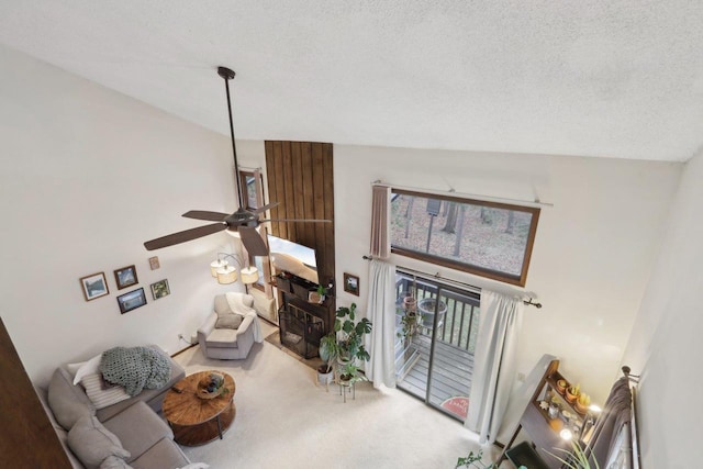 carpeted living area with a textured ceiling and a ceiling fan