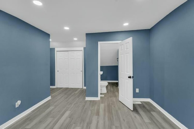 interior space with baseboards, recessed lighting, wood finished floors, and a closet