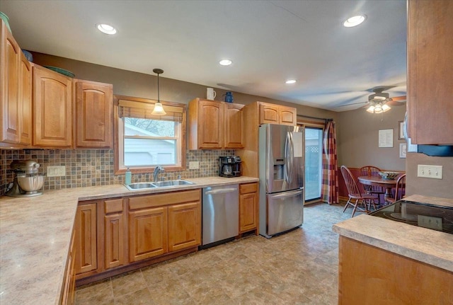 kitchen featuring backsplash, a sink, light countertops, stainless steel appliances, and a wealth of natural light