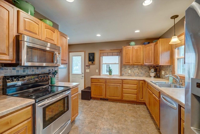 kitchen featuring a sink, appliances with stainless steel finishes, tasteful backsplash, and light countertops