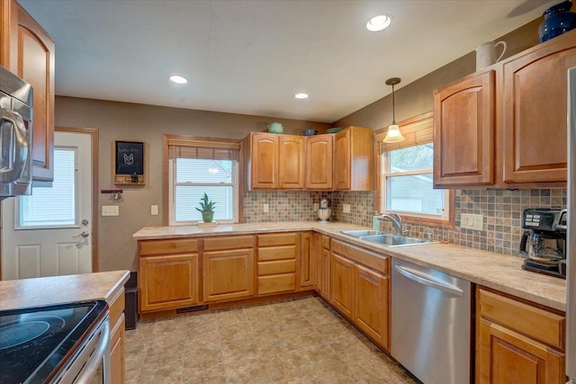 kitchen featuring light countertops, a sink, decorative backsplash, and stainless steel appliances