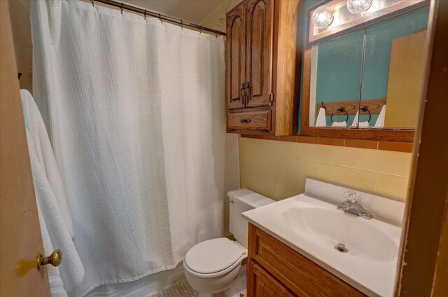full bath featuring shower / bath combo, vanity, toilet, tile walls, and decorative backsplash