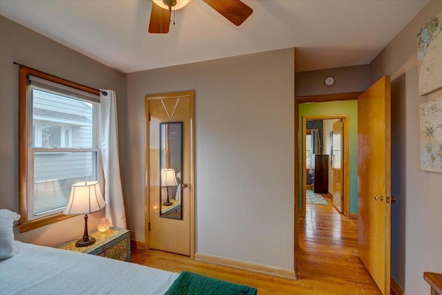 bedroom with baseboards, a ceiling fan, and light wood finished floors