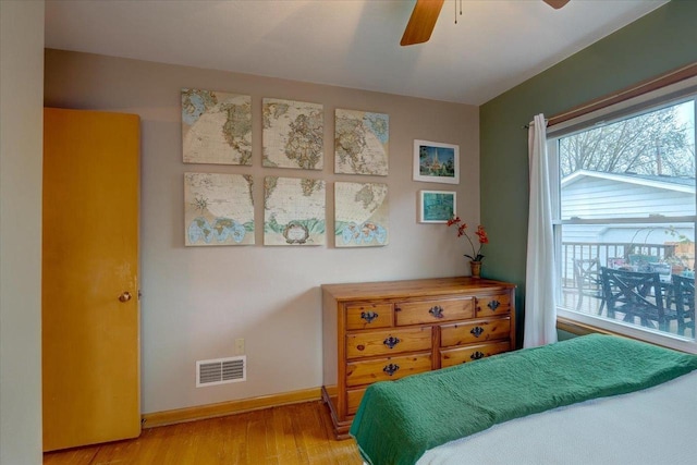 bedroom featuring baseboards, multiple windows, light wood finished floors, and visible vents