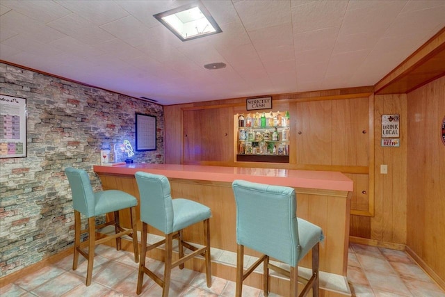bar featuring wooden walls and a dry bar