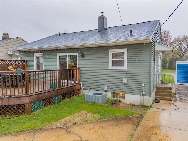 back of property featuring a shingled roof, a wooden deck, a chimney, and cooling unit