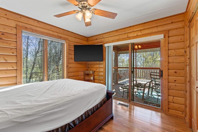 W4895 Big Bay Rd, Necedah, WI 54646 - bedroom featuring access to exterior, wood finished floors, and rustic walls