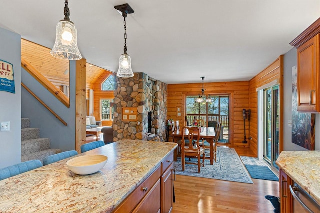 W4895 Big Bay Rd, Necedah, WI 54646 - kitchen with healthy amount of natural light, light wood-style floors, rustic walls, hanging light fixtures, and light stone counters