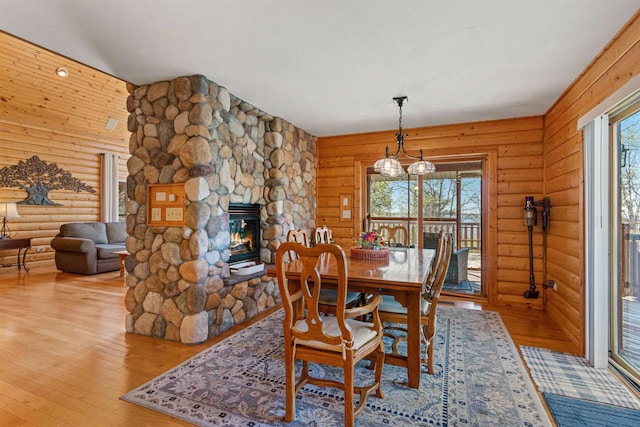 W4895 Big Bay Rd, Necedah, WI 54646 - dining area with log walls, hardwood / wood-style flooring, and a fireplace