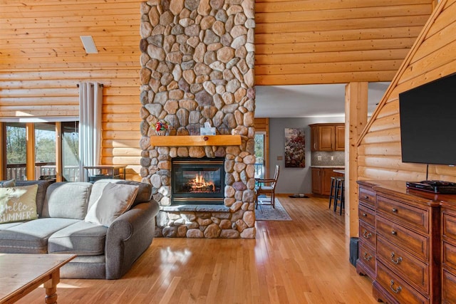 W4895 Big Bay Rd, Necedah, WI 54646 - living room featuring log walls, light wood-type flooring, plenty of natural light, a stone fireplace, and a towering ceiling