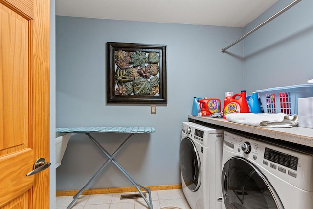 W4895 Big Bay Rd, Necedah, WI 54646 - laundry area featuring washer and clothes dryer, baseboards, and light tile patterned floors