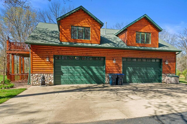 W4895 Big Bay Rd, Necedah, WI 54646 - chalet / cabin featuring stone siding, concrete driveway, and roof with shingles