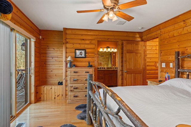 W4895 Big Bay Rd, Necedah, WI 54646 - bedroom with rustic walls, access to exterior, light wood-style floors, ensuite bath, and a ceiling fan