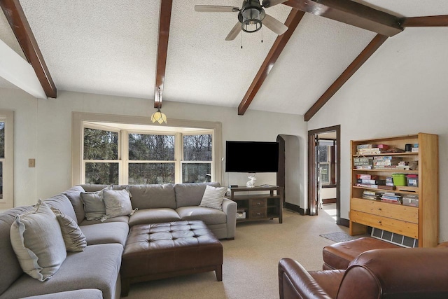 living area featuring lofted ceiling with beams, light carpet, and a ceiling fan