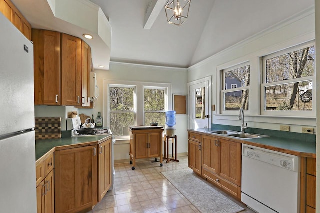 kitchen featuring dark countertops, white appliances, high vaulted ceiling, brown cabinets, and a sink