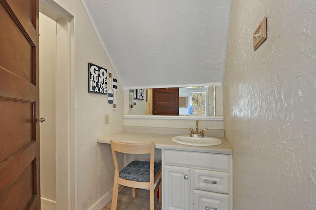 bathroom with a textured wall, vanity, a textured ceiling, tile patterned floors, and baseboards